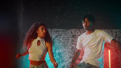 Young Man and Woman Dancing in Modern Lit Room