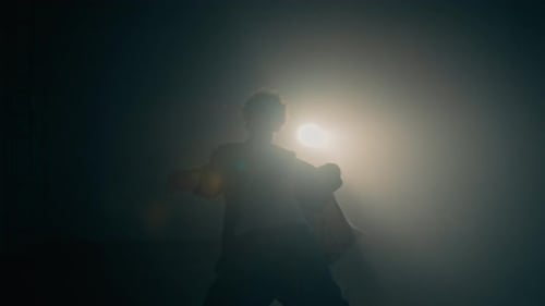 Male Dance Performer Silhouetted against Glowing Backlight