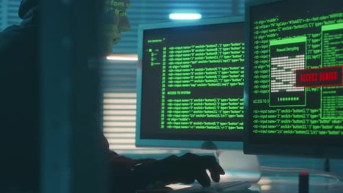 Hacker in a White Mask is Typing on a Computer Keyboard and Cracking a Password