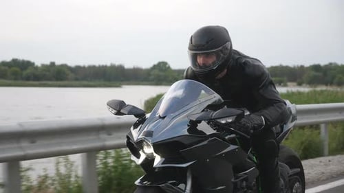 Man Riding on Modern Sport Motorbike at Countryside Road Near River or Lake Motorcyclist Racing His