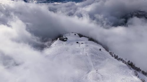 Cinematic Aerial Flight Over Misty Snow Covered Alpine Mountain Peaks