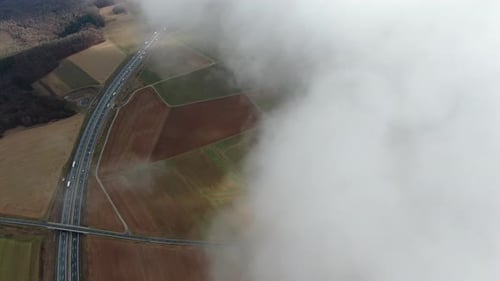 Top view on a highway with traffic, from the fluffy clouds, 4k