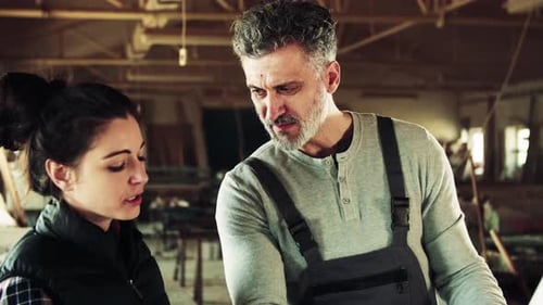 Man And Woman Workers In The Carpentry Workshop.