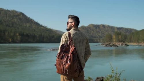 Hiker Tourist Traveler Man with Backpack and Boots at Mountain River Hiking Travel Landscape Nature