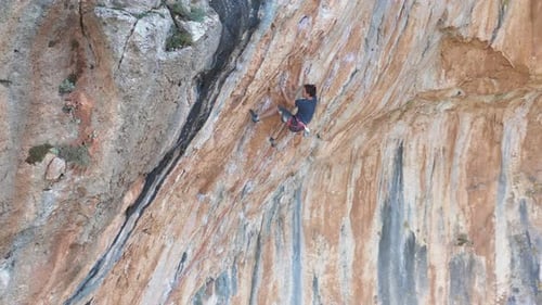 Mountain climber is climbing overhang mountain wall