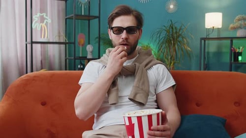 Man Eating Popcorn and Watching a Movie