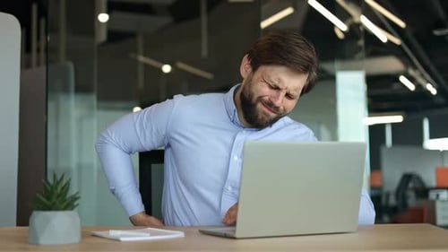 Young Businessman with Back Pain Working in Office