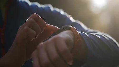 Man Using Smartwatch Outdoors in Bright Sunlight