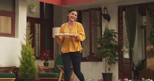 Woman Bringing Snacks to Outdoor Daytime Celebration