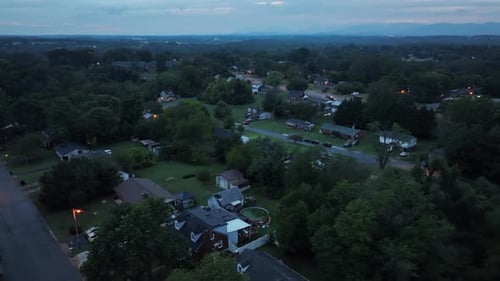 Cozy dusk scene in suburb residential area of American Town. Traffic on interstate road. Aerial