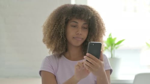 Young Woman Using Smartphone in Bright Home