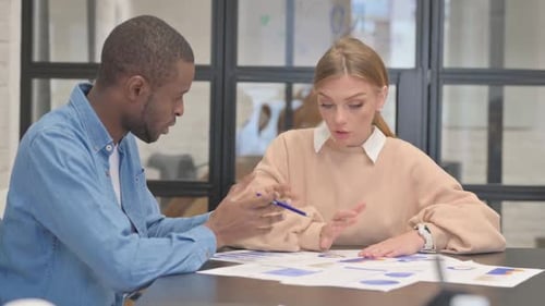 Man and Woman Collaborating on Project at Office