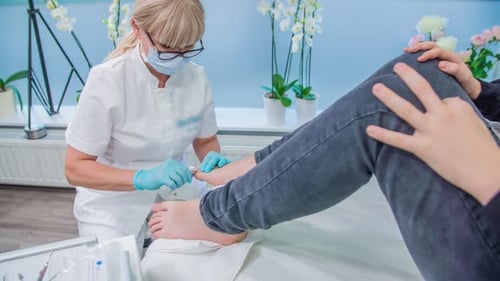 Podiatrist Working on Patient's Toenail in Clinic