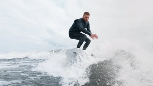 Surfer Skillfully Rides Ocean Wave Showcasing Dynamic Movement and Water Splashes