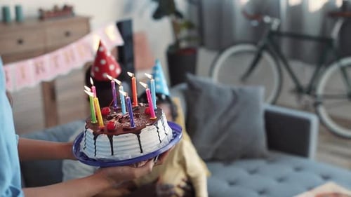 Family Celebrates Birthday with Cake and Candles Indoors