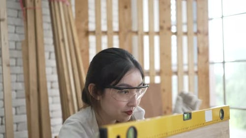 Carpenter is working at woodshop.