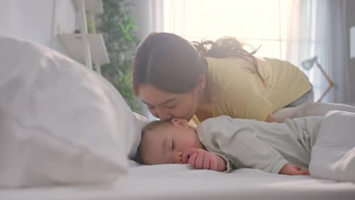 Loving Mother Watching Sleeping Baby at Home