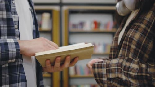 Engaging Conversation Between Two Individuals About a Book in a Cozy Library Setting During the
