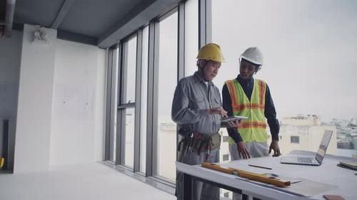 Construction Workers Looking at Blueprint on Tablet Computer