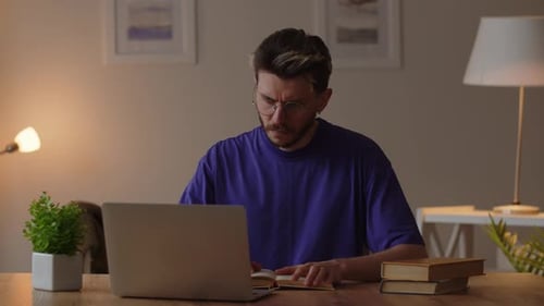 Young Adult Reading Book at Desk Indoors
