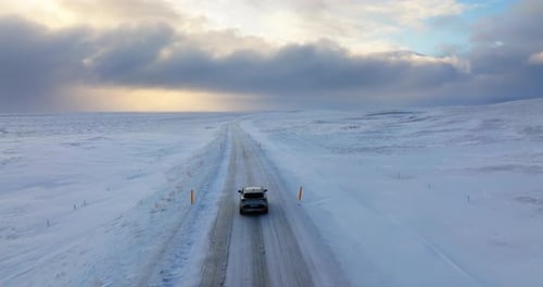 Car Driving on Snowy Road in Winter Landscape