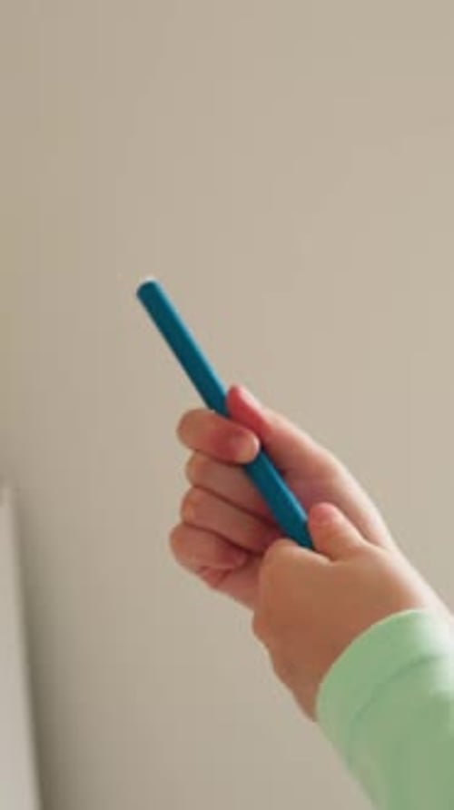 Child Drawing with a Blue Marker Close Up