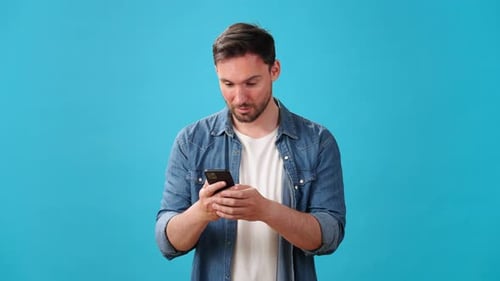 Man Celebrating Success While Using Smartphone