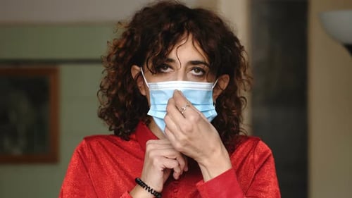 Woman Puts on Surgical Mask Close Up