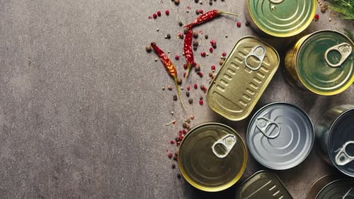 Latas de metal con comida enlatada o paté, vista desde arriba, latas doradas y plateadas con anillos para tirar, enlatadas