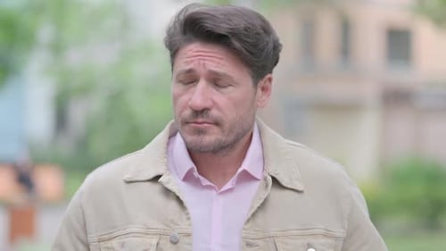 Man Looking at Watch Outdoors During the Day