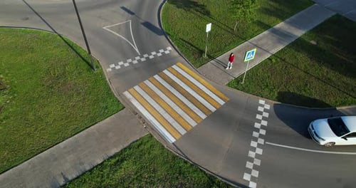 A White Car Stops in Front of a Pedestrian Crossing a Girl Crosses the Road