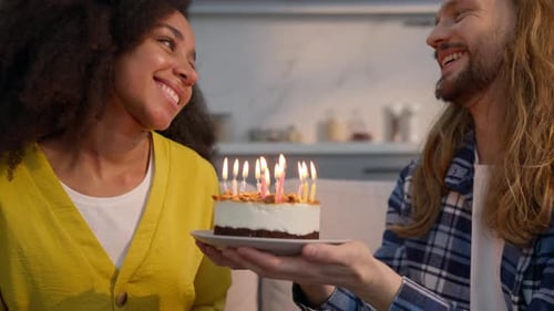 Joyful Multiracial Couple Celebrating Birthday at Home Caucasian Man Holding Cake African American