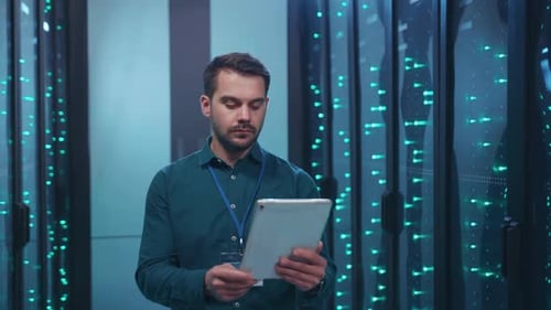 A Dedicated Professional Engaged in Data Center Operations While Utilizing a Tablet Device