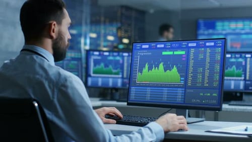 Trader en bourse travaillant sur un ordinateur affichant les numéros et les graphiques des actions.