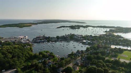 Drone shot of Cape Cod's lush green land intermixing with the surrounding ocean.
