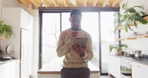 Man Using Tablet in Bright Modern Kitchen