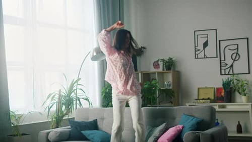 Woman Dancing on Couch in Living Room