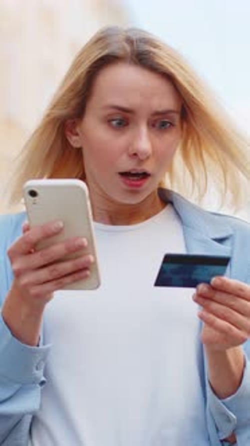 Woman with Phone and Credit Card Looks Concerned