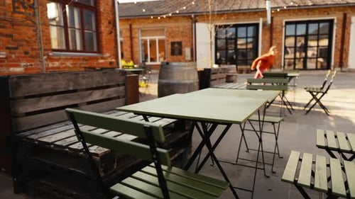 Tables and Chairs on the Patio Outside a Brick Building