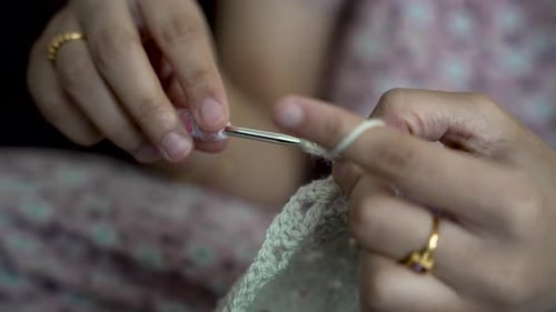 Hands Crocheting Handmade Textile with White Yarn