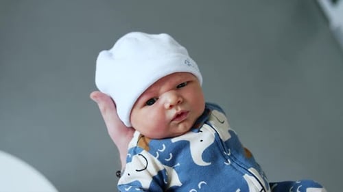Adorable Newborn Baby Being Held Indoors
