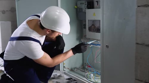 Electrician Working on Wiring in Electrical Box