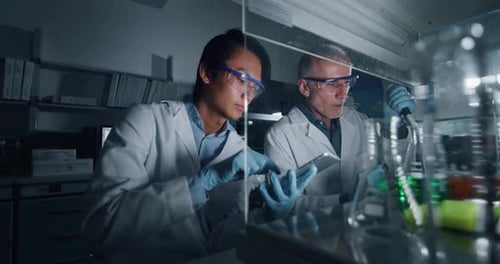 Portrait of two male scientists are making an analysis of the DNA and molecules in the test tubes