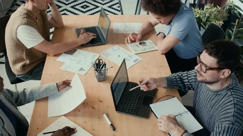 Grupo de colegas discutiendo los problemas del proyecto en una reunión de negocios en la oficina