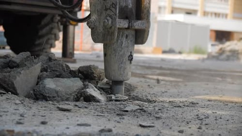 Hydraulic Breaker Loosens and Breaks Old Asphalt in City