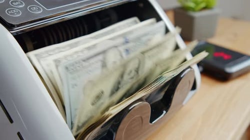 Automatic Money Counting Machine Processing Stacks Of US Dollar Bills