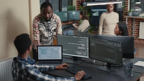 Softwareentwickler überprüft Programmierdaten an einem Computerarbeitsplatz mit sitzender Arbeitsstation