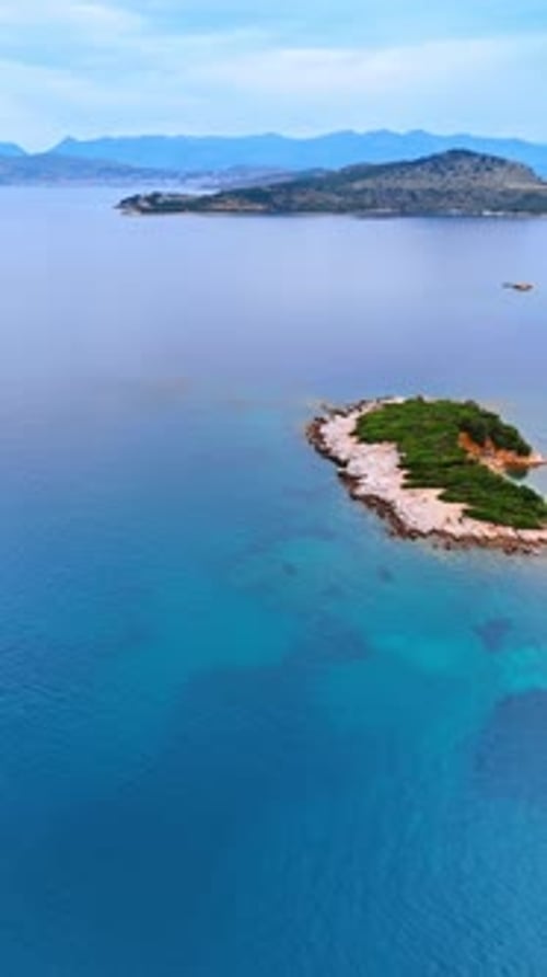 Turquoise waterscape with little islands surrounded by mountains.