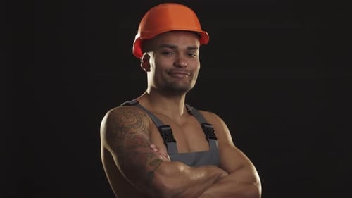 Confident Muscular African Male Builder in Hardhat Giving a Thumbs Up