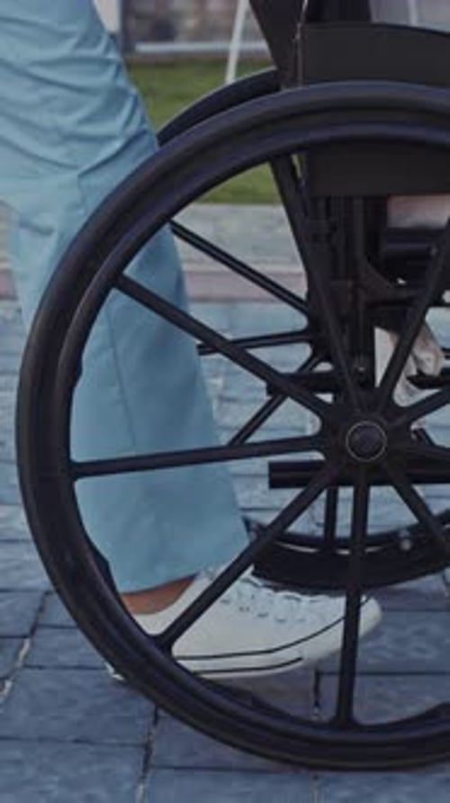 Wheels of a Wheelchair Rolling on Stone Path